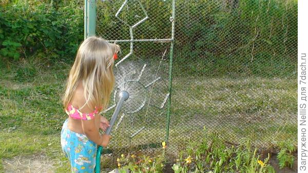 Внучка поливает забор