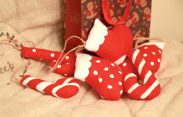 Радостную яркую нотку в новогоднее оформление можно добавить бело-красными леденцами и носочками. Такие мягкие игрушки можно использовать как украшение, а можно - как милый приятный подарок.