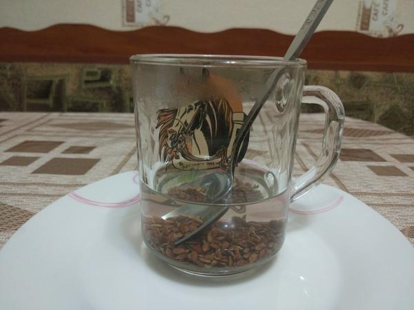 Фото 2. Запотевший верх стакана указывает на то, что вода горячая, ложка - на то, что семена размешиваются))