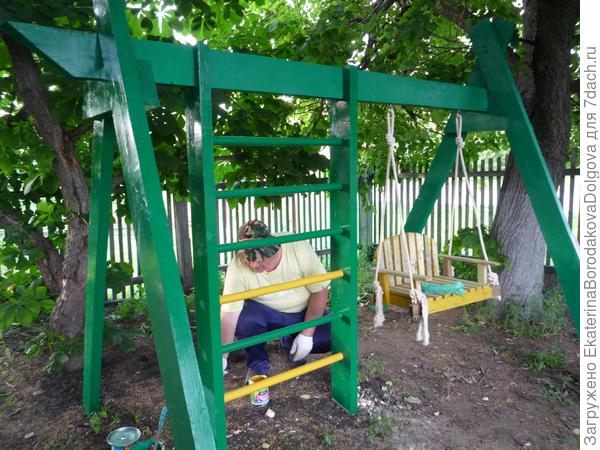 Идет покраска качелей и стенки