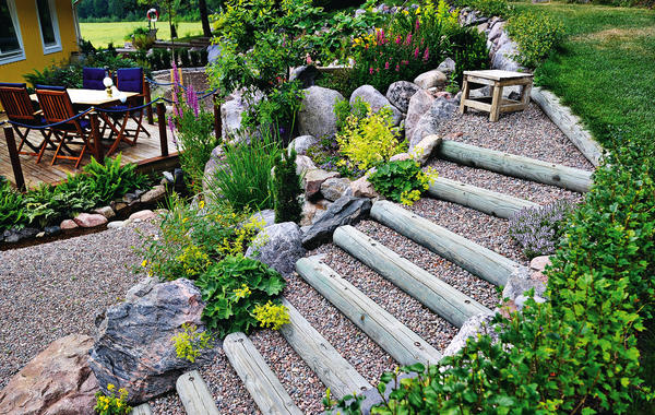 Если дом расположен на небольшом возвышении, сформируйте палисадник в виде террасного сада с широкими ступенями