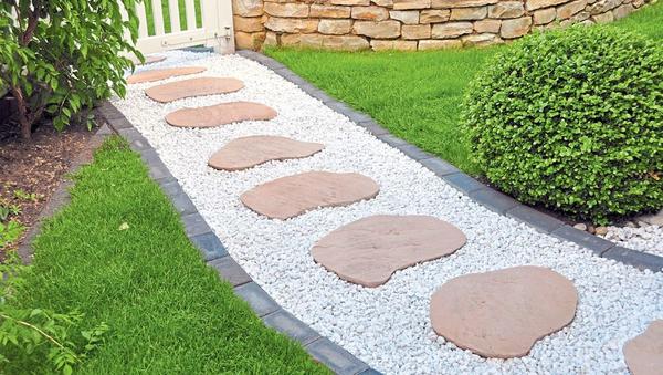 Гравийную дорожку всегда можно дополнить другим материалом, например каменными плитами