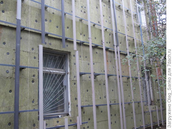 На горизонтальные кронштейны нанизаны теплоизоляционные плиты