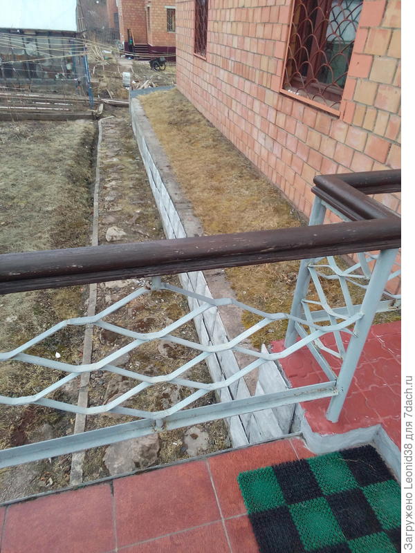 Северная сторона дома, видно отмостку, дорожку из камня, и дренажную канавку вдоль бордюра . Для отведения паводковых вод с склона.