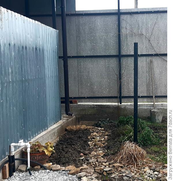 От трубы идёт небольшой склон, поэтому я просто направила оттуда канаву, заполненную щебнем