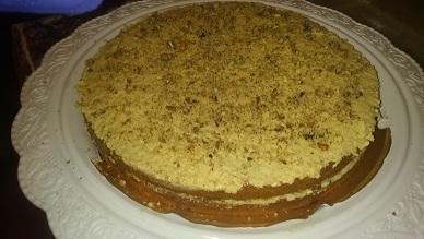 Коржи, пропитанные коньяком и намазанные кремом и посыпанные дробленым грецким орехом