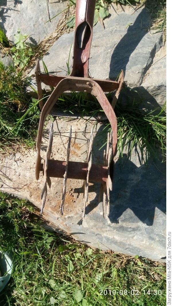 На длинной ручке на раме закреплено две рабочие части: П-образный резак и четыре звездчатых колеса, закрепленных на одной оси.