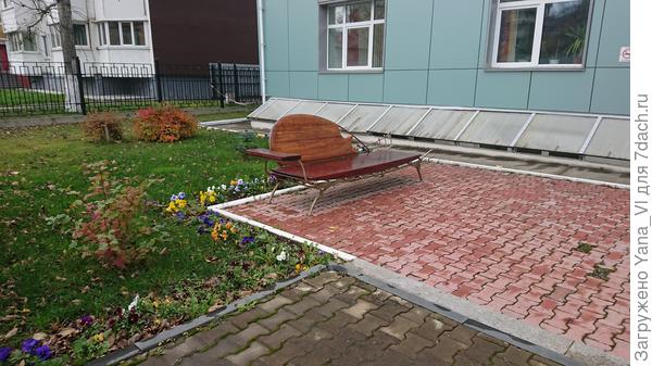 Красивая лавочка во дворе здания