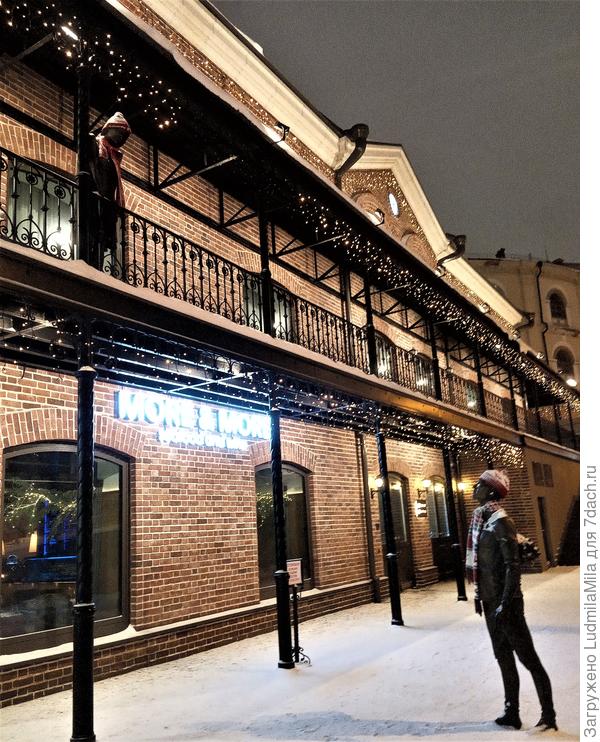 Парень с девушкой.Он пришел на свидание с букетом цветов.Она стоит на балконе.