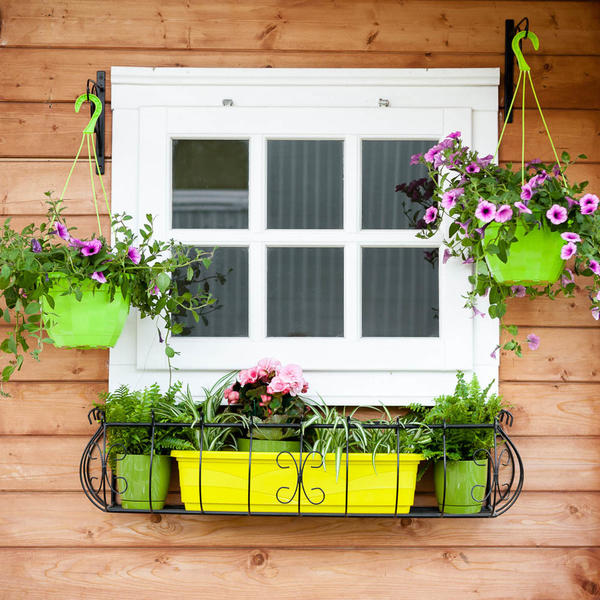 Украсьте фасад дома с помощью цветов в кашпо, установленных в длинном подвесном держателе
