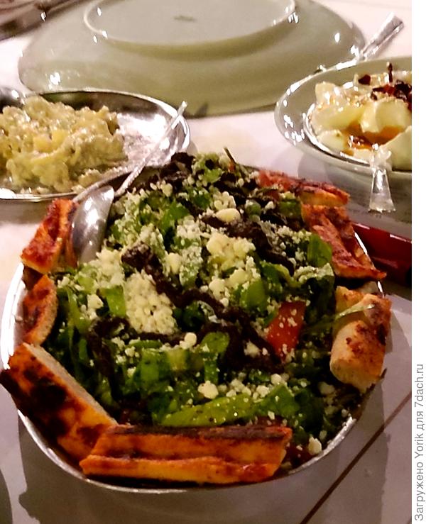 Салат из зелени направленный нежирным соусом, посыпанный овечки сыром. Лепёшки обамзаны смесью перетертых оливок, печеного острого перца.