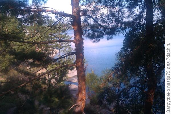 Домики на горках, внизу камни, песок, вода