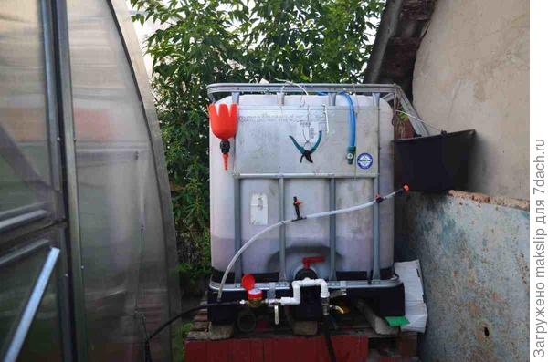 Кубовый бак с водой. Слева счетчик для контроля полива. Справа ведро для налива раствора для подкормки.