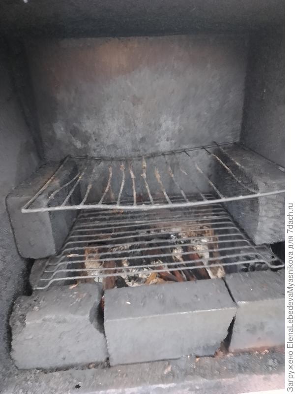 Внутри ещё все сделано на скорую руку. Надо сделать капитальные решетки. На дно ящика насыпаем стружку ольхи или яблоки. Она дымит от жара из топки