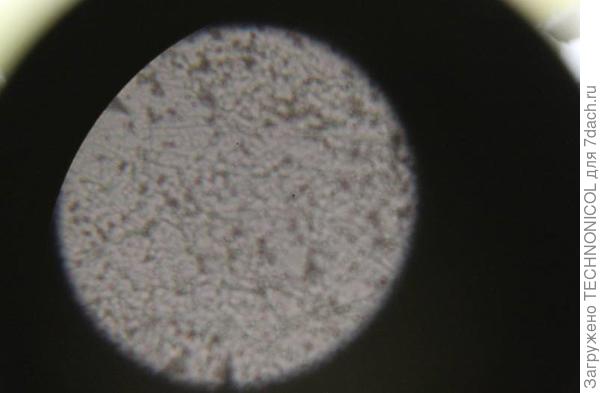 Пористая (и неровная) поверхность тяжелого бетона, при увеличении оптическим микроскопом.