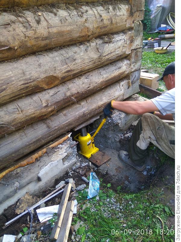 Каждый угол поднимали по очереди, по немногу. Когда высота была достаточной заталкивали брус.