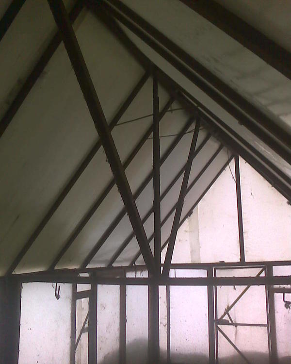Одна из центральных балок с распорками. Сверху тоненькие между профилями - это, пожалуй, больше так, остались железки и я их не больно-то ровно когда-то при царе горохе приварил вроде распорок. Вообще крыша узкая, поэтому распорок здесь приварено намного меньше, будь теплица шире, центральная балка была бы подперта под углом по линии крайних грядок двумя наклонными опорами от вертикально стоящих швеллеров стен, и между всеми наклонными балками были бы приварены распорки по типу буквы А. Но здесь нешироко, поэтому хватило пяти распорных балок от стен, выше распорки приварены где попало и больше так, из остатков случайной арматуры, наспех и неровно.