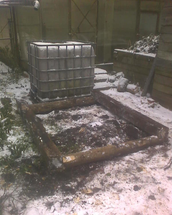 Вот справа готовый компостный ящик, но он доверху завален тепличной ботвой (пасленовой, для коз непригодной), а слева вот сегодня "разметил" новый ящик. Эдакая брусовая или бревенчатая "изба" без дна, дно просто почва и ничего я даже не изобретаю там. Первые уложил, дальше думаю где-то на метр подняться. Ну и это служит мусоркой - туда кидается в основном тепличная ботва горами, козий навоз и пищевой мусор, непригодный ни для чего другого (что нельзя давать курам, уткам и т.п., тут просто - с огорода очистки от огурцов давать можно, зимой покупные - нельзя, потому что они обработаны могут быть чем-то и потравить можно птицу, вот их только в компост гнить и всё). Ну вот, а когда этот ящик почти полон будет, я туда накидаю в своём стиле козьего навоза зимнего слой, и посажу кабачки или тыквы. Они в таких мусорных ящиках на удивление бодро и хорошо растут. Ну и тыквы обычно вьются, лезут вверх - вот на эту водяную ёмкость (она служит для полива теплицы, в неё с крыши вода дождевая собирается) тыква сможет виться. Они обычно длинные плети пускают, заполоняя дорожки и т.п. Брус на эти ящики, конечно, б/у,  новый дорогой брус я так бы тратить едва ли стал. Пара бревен от сваленного в этом году дерева и брус дальше. Зима начинается, но можно делать, главное что низ сделан и нет мук с мерзлой землей, поедет там чего, не поедет, криво, не криво - а то уложишь на лед не глядя, а оно потом растает и набекрень всё станет. Успел, как раз успел всё.
