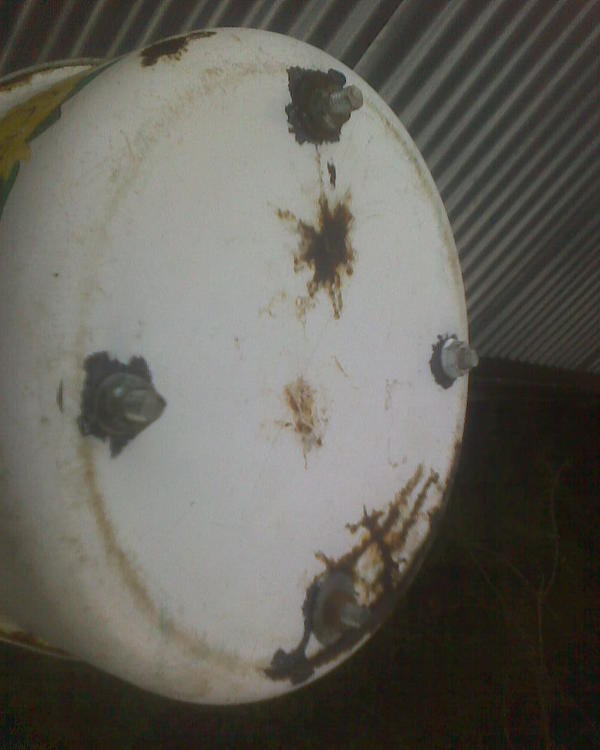 Просверлил этот шедевр привинтил эти шпильки на гайки с шайбами. а внизу (предыдущее фото) скрепил двумя какими-то мусорными, но вполне крепкими стальными трубками, просверлив их и свинтив болтиком тоже. Будь у трубы тяга хуже - я бы не стал так перегораживать газоход, но тут всё наоборот, труба тянет как кузнечный горн, поэтому тягу недурно бы снизить, ну и я присобачил такое вот на трубу, чтобы и искры не так вылетали (там сосна рядом) и дождь туда внутрь не лил. Трудно сказать, через сколько времени эта кастрюлька превратится в труху, но чего, помяню, а вот посадочные шпильки, вероятно. послужат. Они так хорошо наделись на трубу, что их не пришлось ничем даже приматывать вроде проволоки или стальной стяжки. наделись как носок на ногу. Если надо будет чистить трубу или менять кастрюлю - сниму. Надеюсь эмаль на кастрюле не будет сильно пылать от горячего газа. Посмотрим. Лестницу пока не убираю, а завтра печку растоплю, проверю чего это такое получилось.