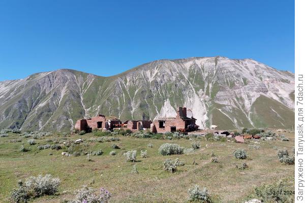 Вдали виднеется заброшенное селение. Коровы любят там прятаться от солнца.