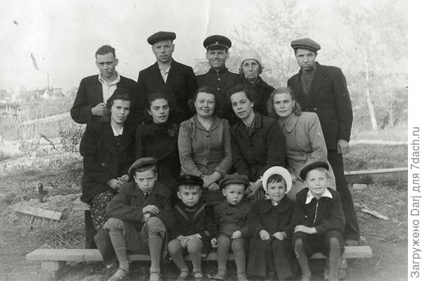 Наверху в центре дедушка, второй ряд крайняя справа бабушка, первый ряд второй слева папа. Остальные - родственники и соседи.