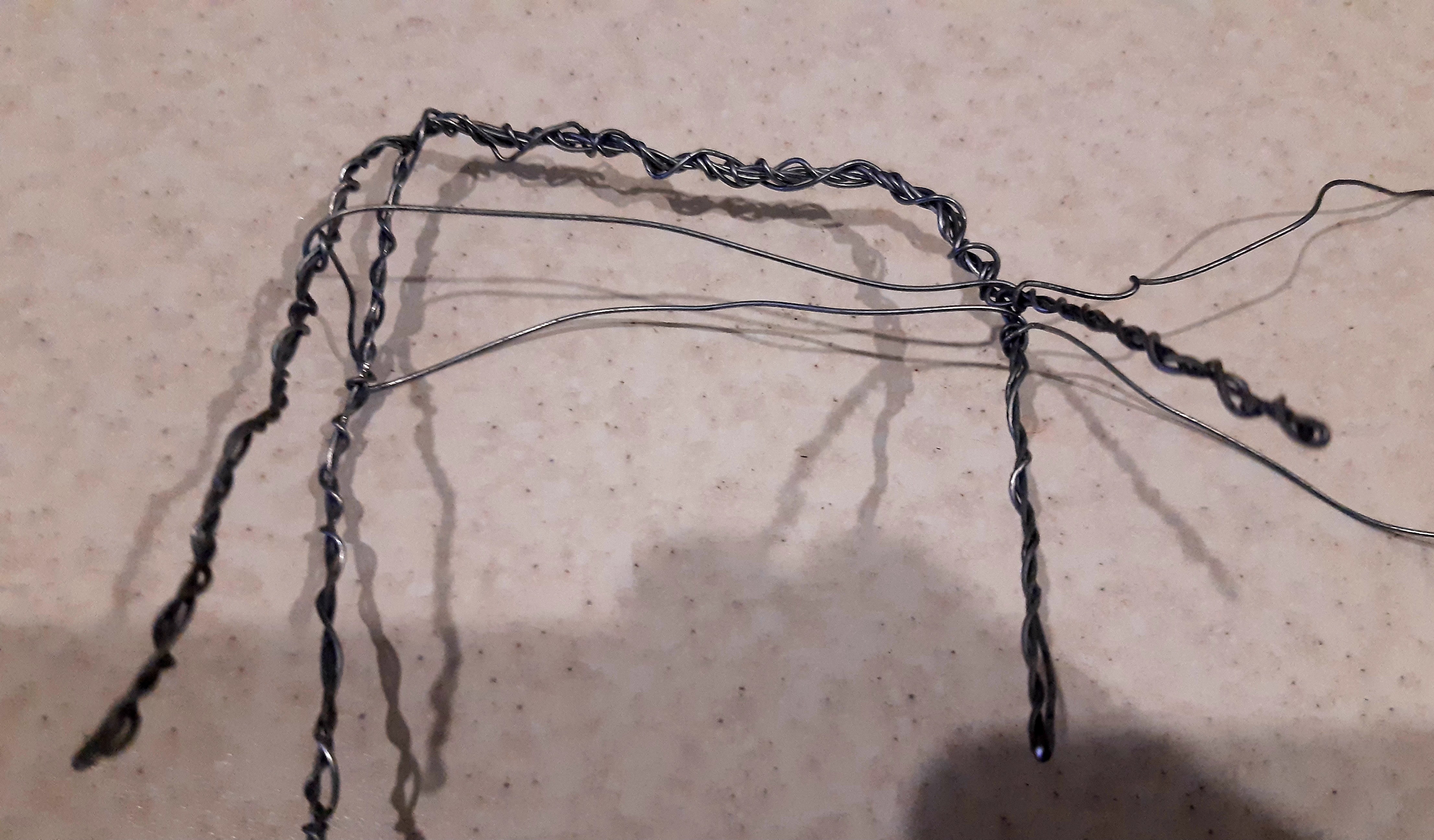 От передних ног пропускаем проволоку, распределяя концы по бокам фигурки